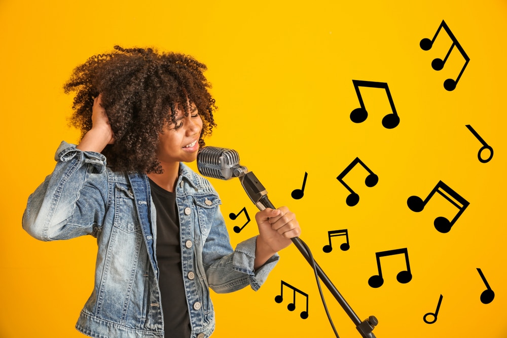 African american,Girl,With,Microphone,Singing,Against,Color,Background