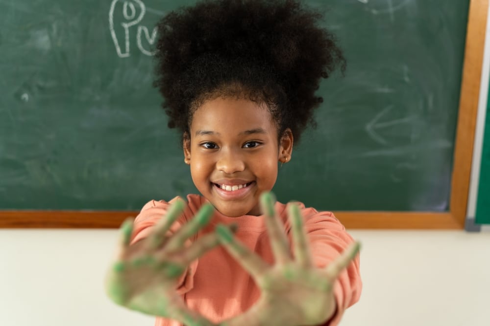 Smiling,African,American,Girl,In,Classroom,With,Green,Paint,On
