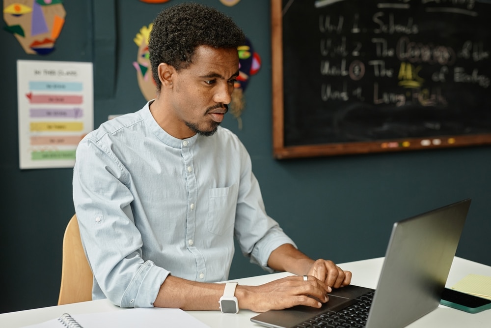 Medium,Shot,Of,Concentrated,African,American,Male,Teacher,Sitting,At